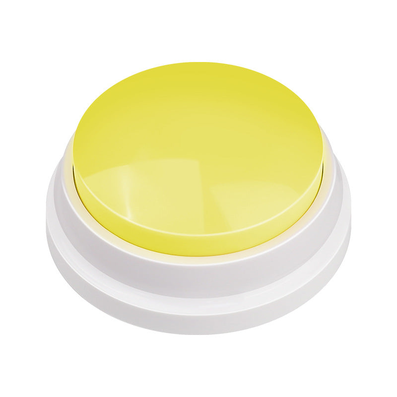 Botón grabable amarillo sobre suelo de madera, con la base blanca antideslizante