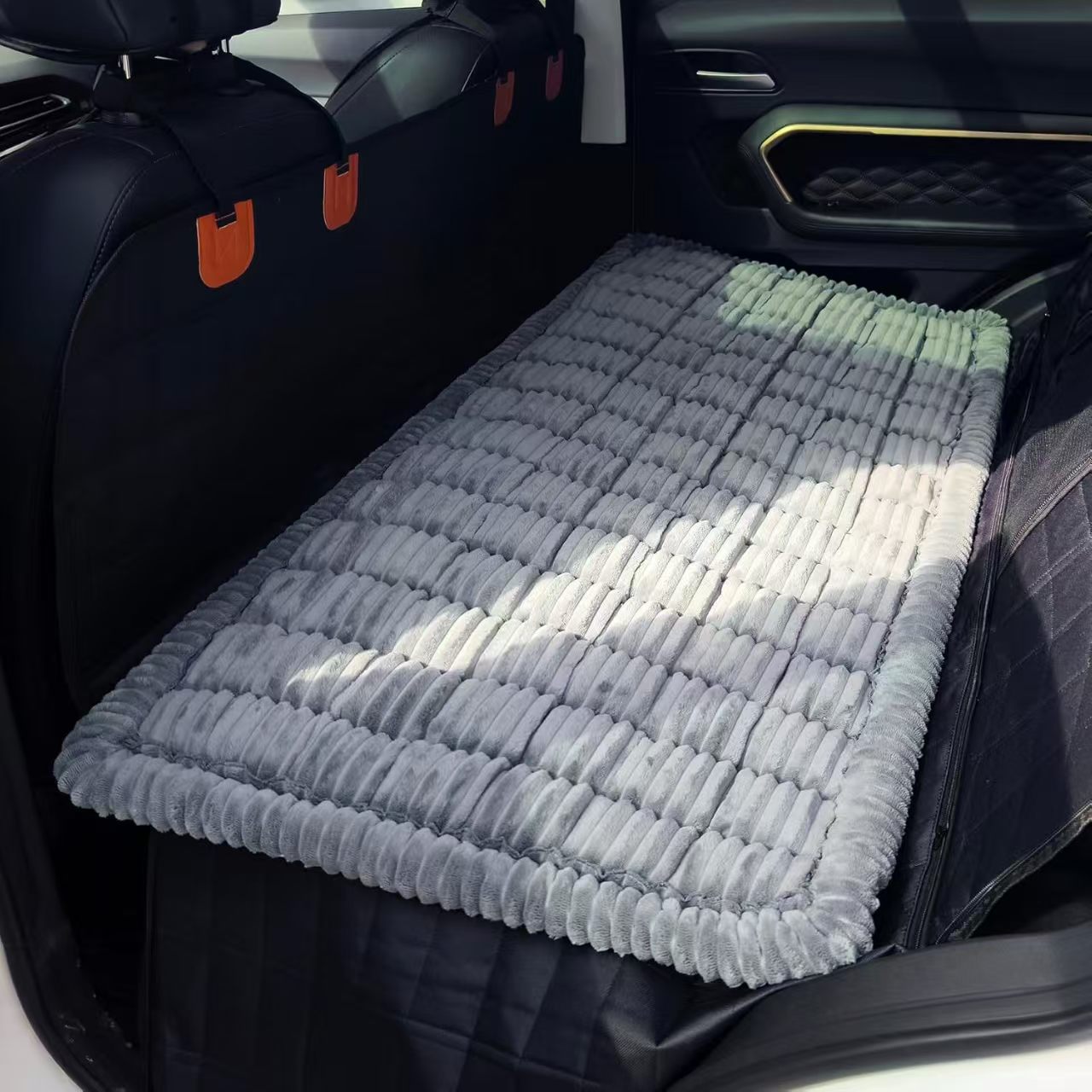 Perro tumbado sobre la funda del asiento trasero